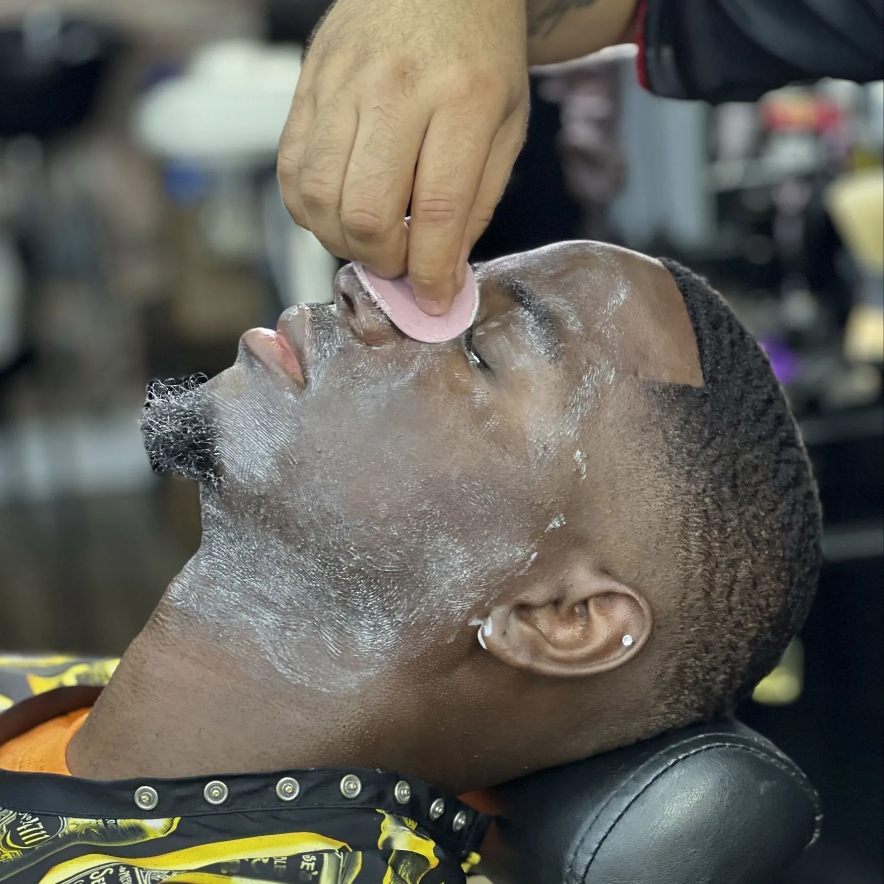 Hot towel and shave cream treatment during a VIP service at DomiBarberz