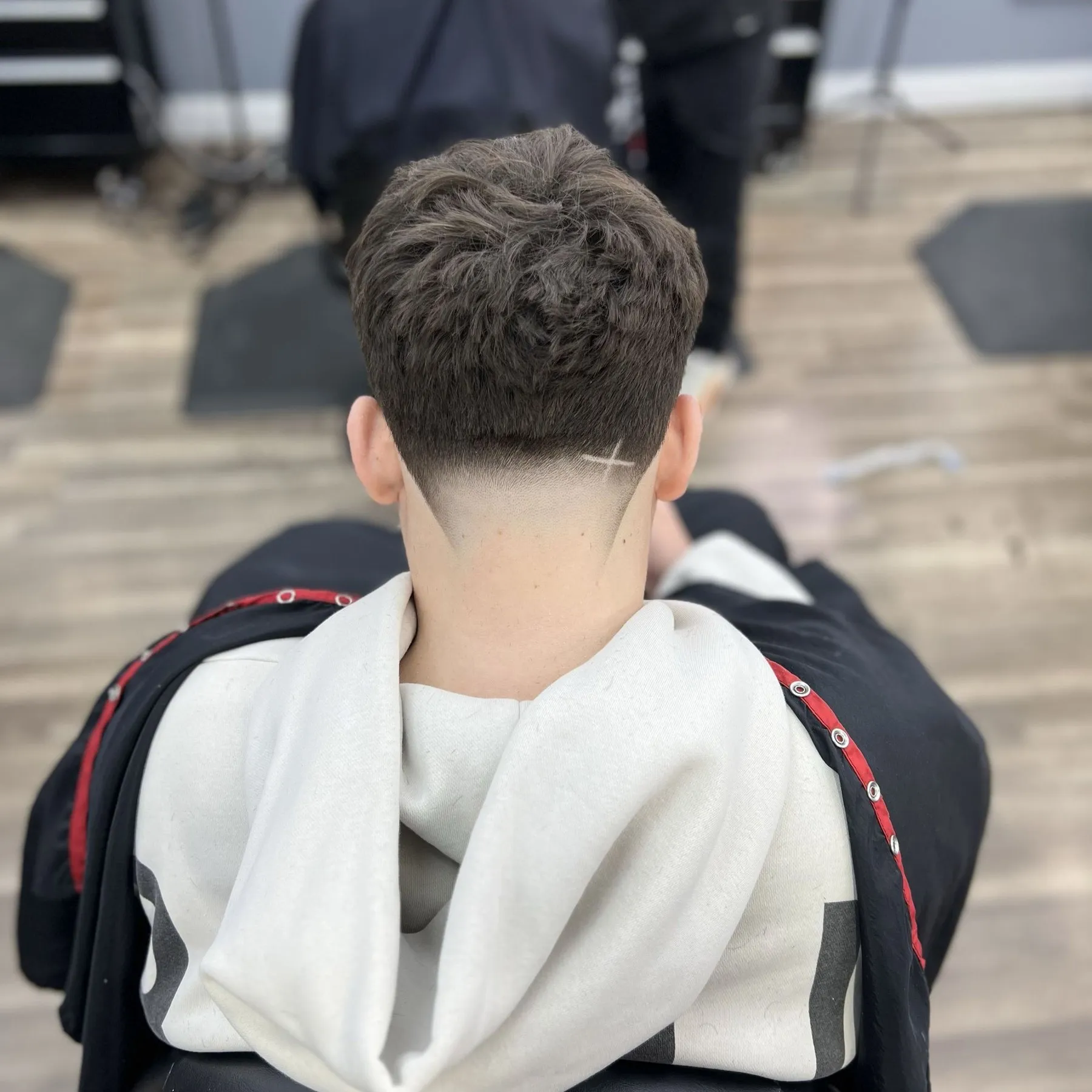 Low taper with a clean razor neckline and part line, cut at DomiBarberz